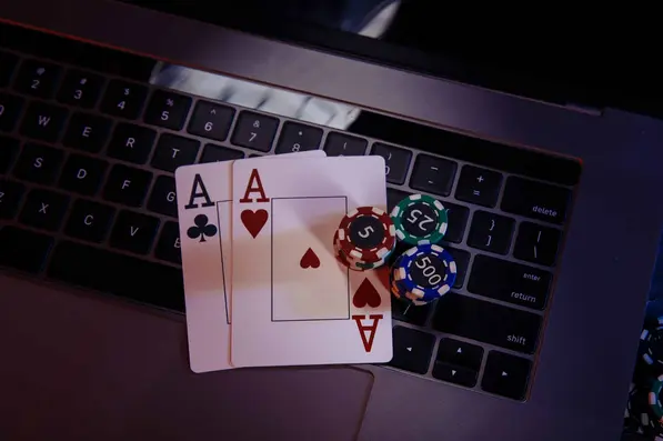 Cartes de poker et jetons posés sur un clavier d’ordinateur
