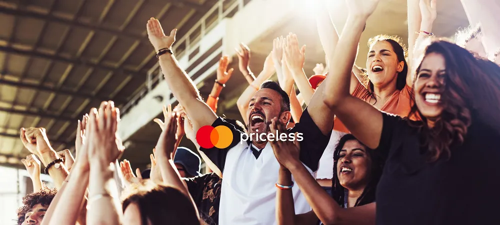 Supporters enthousiastes célébrant un événement sportif avec le logo Mastercard, symbole de paiements simples et sécurisés