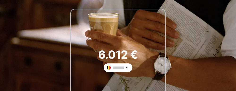 Main tenant un café et un journal avec un solde Revolut affiché à 6.012 €, illustrant un compte Revolut belge actif